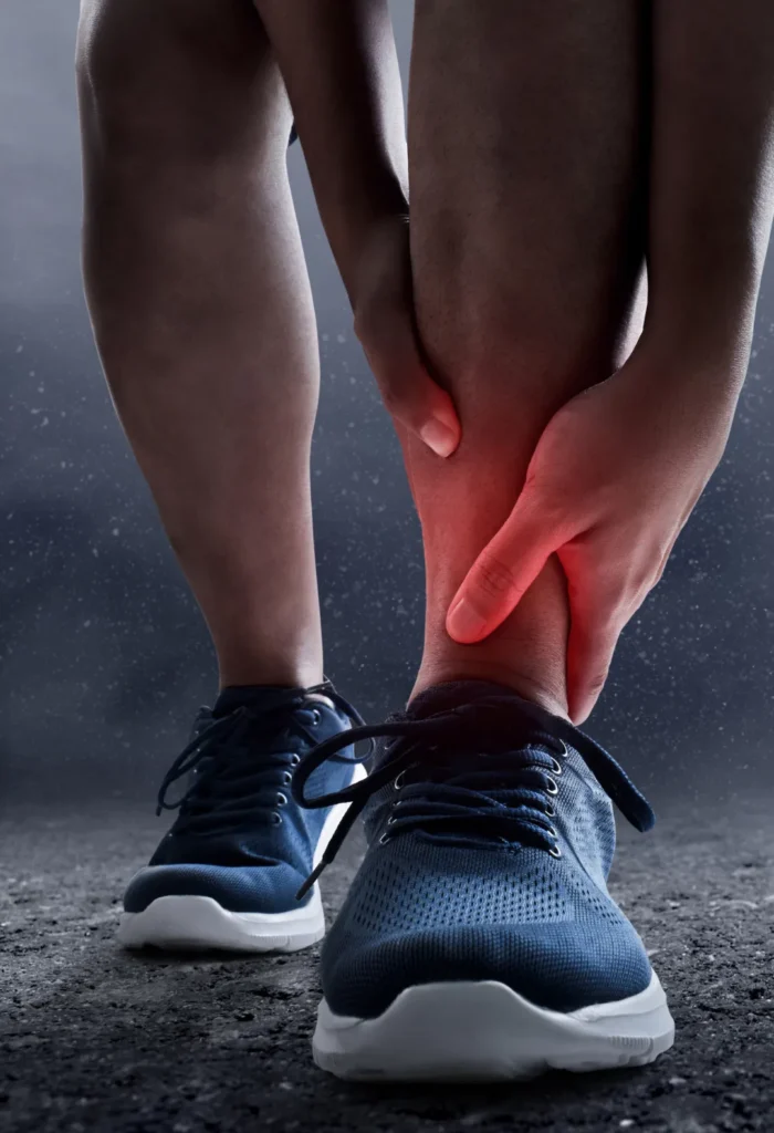 Person holding ankle with pain and swelling due to sports injury or ligament strain